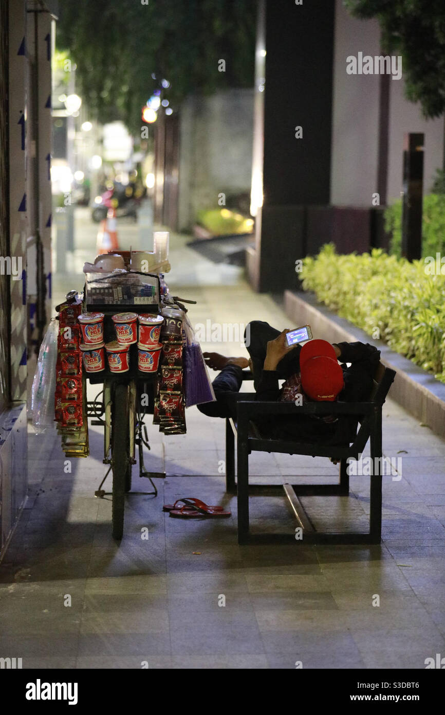 Se détendre et attendre le client. La vie des petits fournisseurs de téléphonie mobile est un défi à Jakarta. - Image de stock capturée avec un smartphone