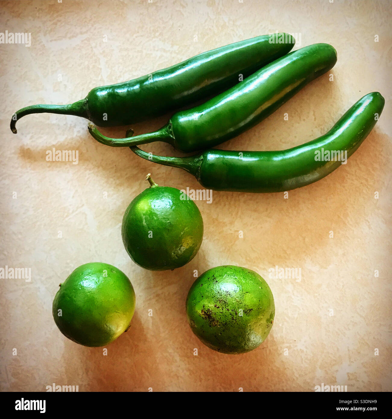 Trois citrons et trois piments verts chauds dans une cuisine au Mexique. Banque D'Images
