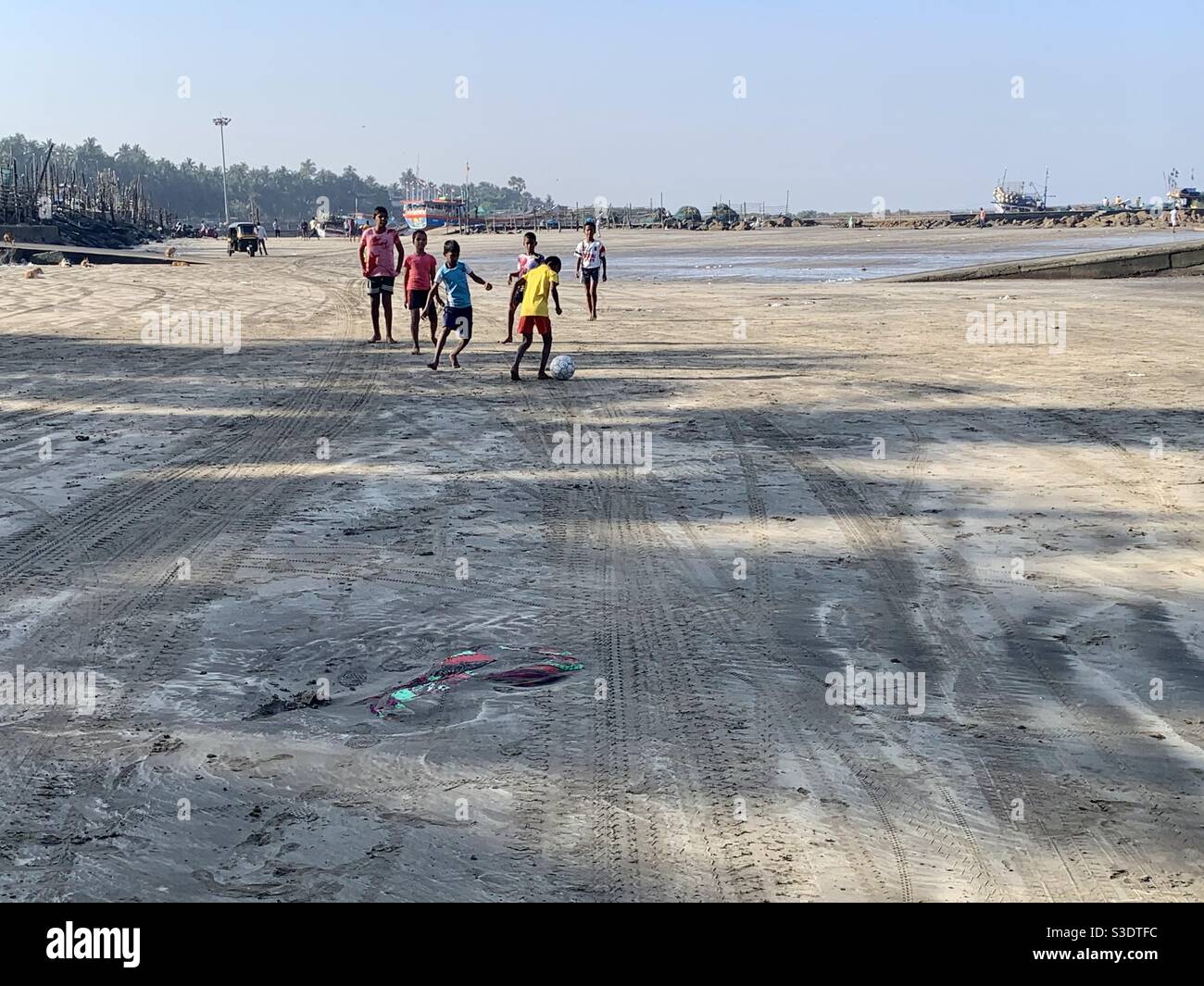 Il est temps de jouer, les enfants jouant au football à la plage de Gorai. Banque D'Images