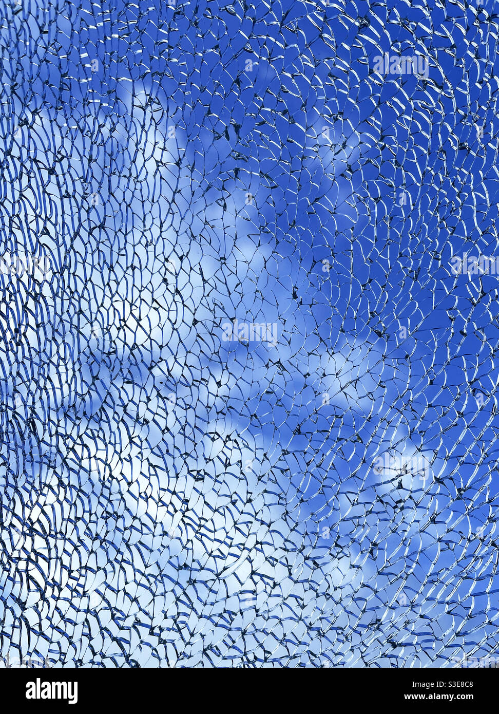 Motif complexe formé de verre renforcé qui s'est brisé contre un fond de ciel Banque D'Images