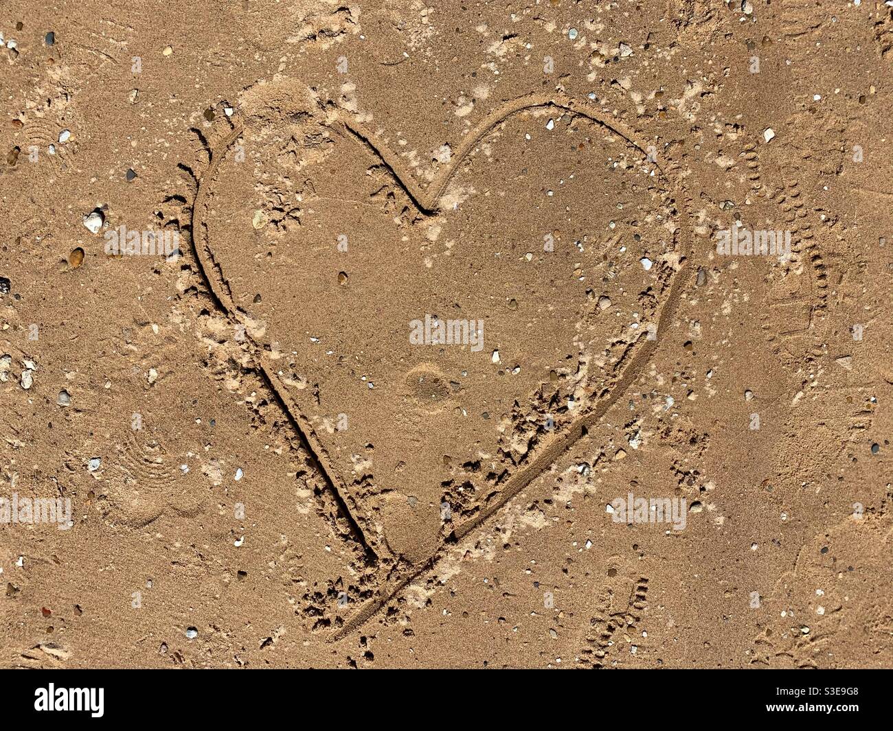 Cœur gravé dans la plage de sable. - Image de stock capturée avec un smartphone