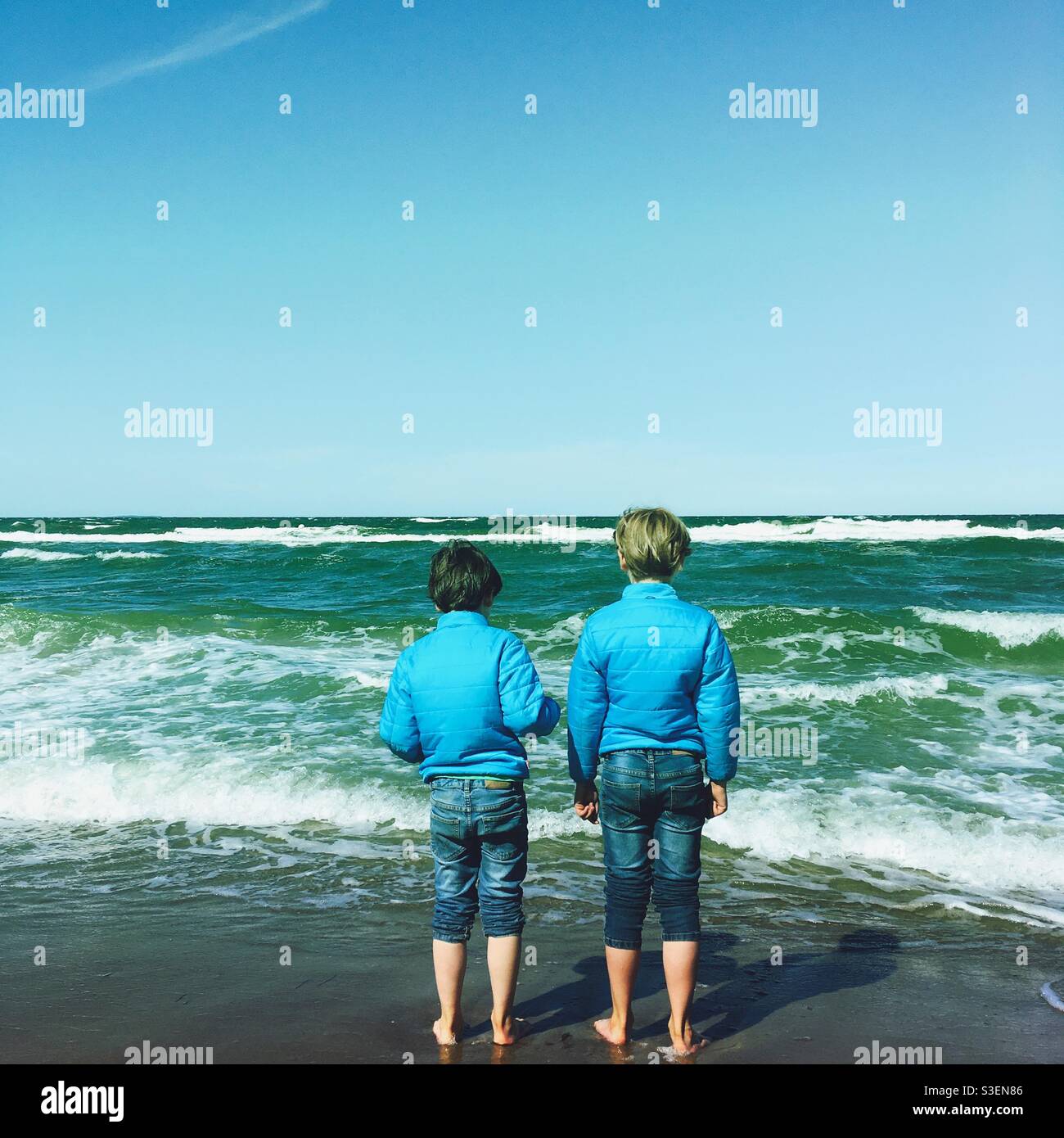 Deux frères en vêtements assortis regardant la mer baltique, l'Allemagne Banque D'Images