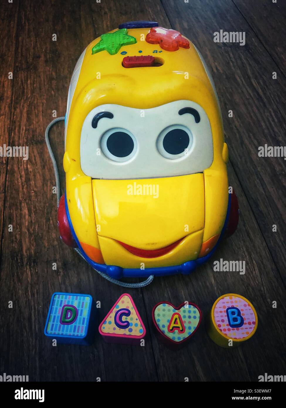 Voiture jouet jaune pour enfant avec lettres en plastique - Image de stock capturée avec un smartphone