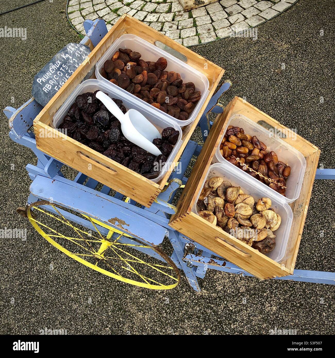 Exposition de fruits secs sur le chariot de l’enfant âgé le jour du marché - France. Banque D'Images
