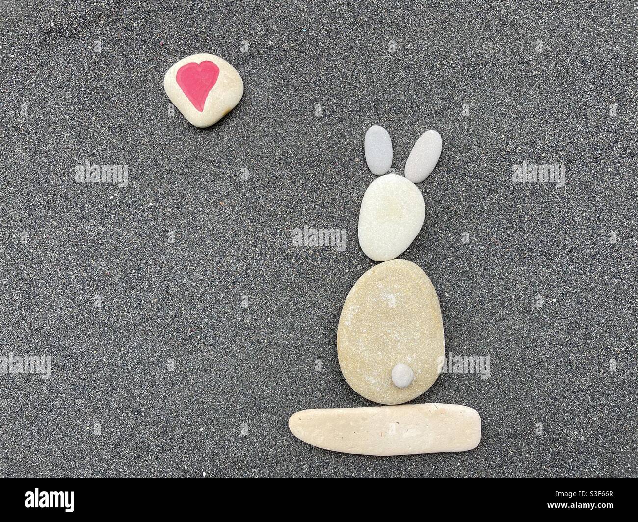 Joyeux Anniversaire A Mon Adorable Lapin Avec Une Composition Creative De Pierres Et De Cailloux Sur Le Sable Volcanique Noir Photo Stock Alamy