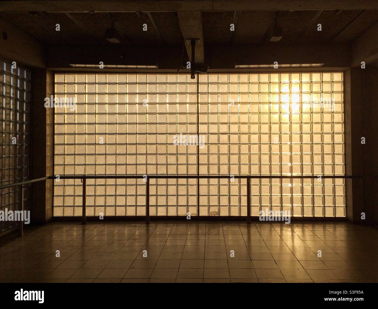 Un mur fait de briques de verre avec la lumière chaude du soleil du soir diffusion en continu - Image de stock capturée avec un smartphone