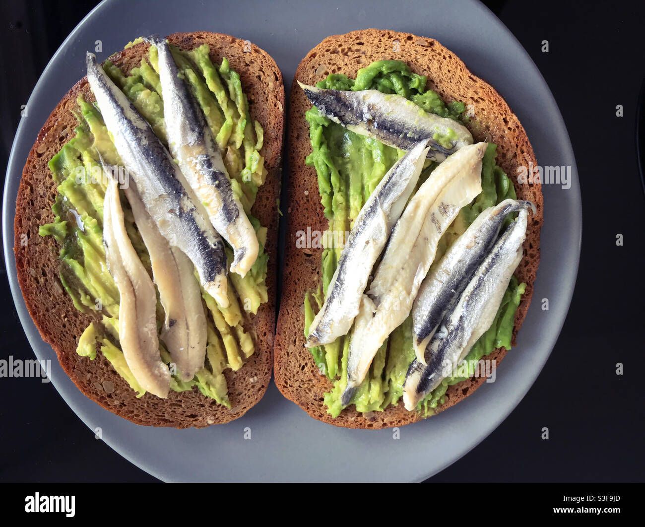 Natures mortes avocat et anchois toast - photographie alimentaire - Image de stock capturée avec un smartphone
