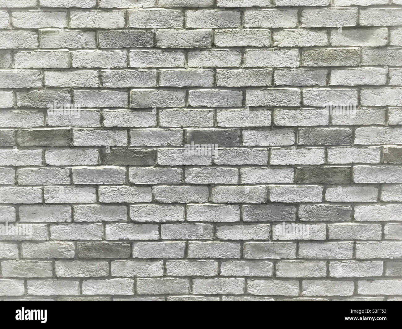 Mur de briques gris clair inégal. Banque D'Images