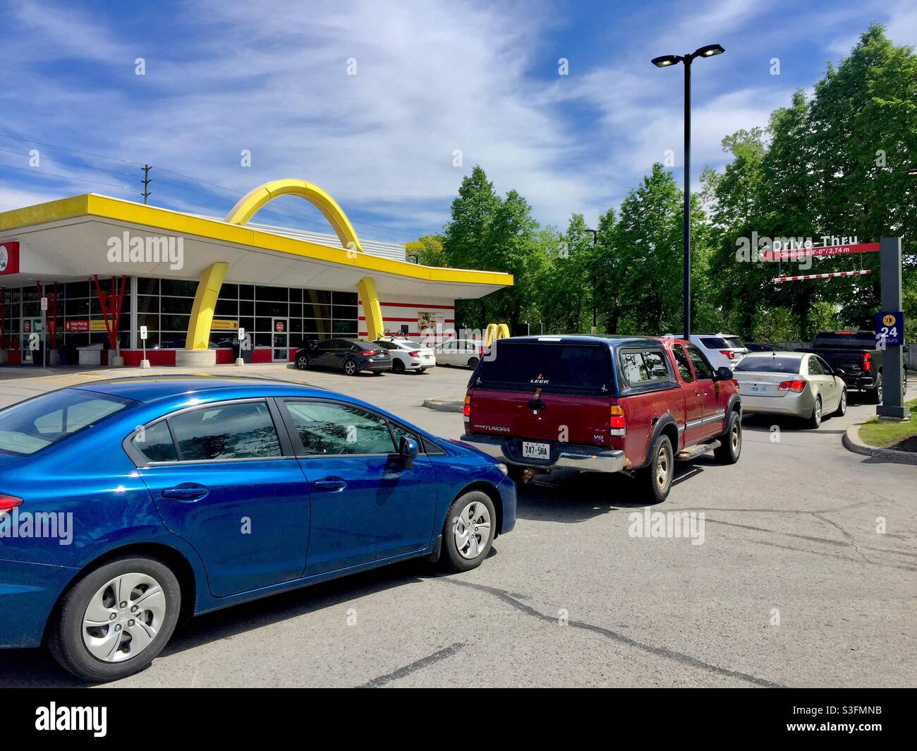 Gamme au McDonalds Drive, Ontario, Canada. Restauration rapide, file d'attente lente aux Golden Arches. Les restrictions Covid augmentent la demande d'aliments sans contact. Banque D'Images