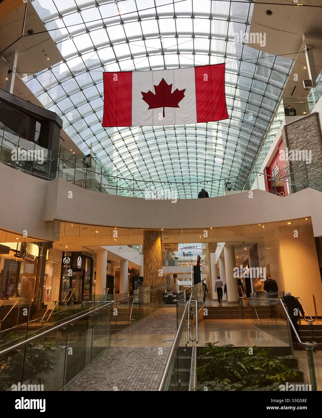 Drapeau canadien suspendu au plafond en verre du centre commercial Core. Centre-ville de Calgary, Alberta, Canada. Banque D'Images