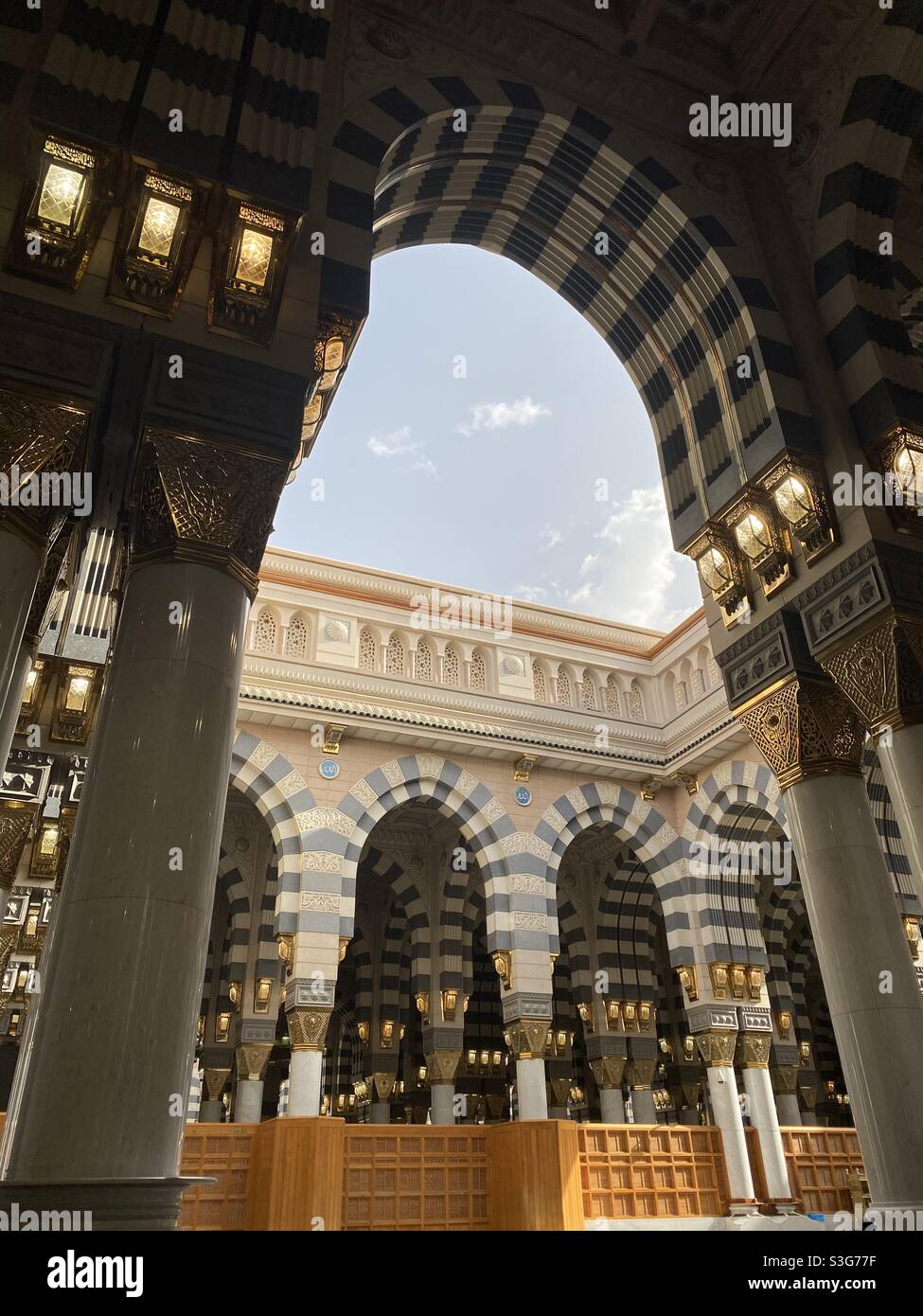 A l'intérieur de la mosquée de Madinah, des piliers et un ciel bleu ciel nuageux en arrière-plan Banque D'Images