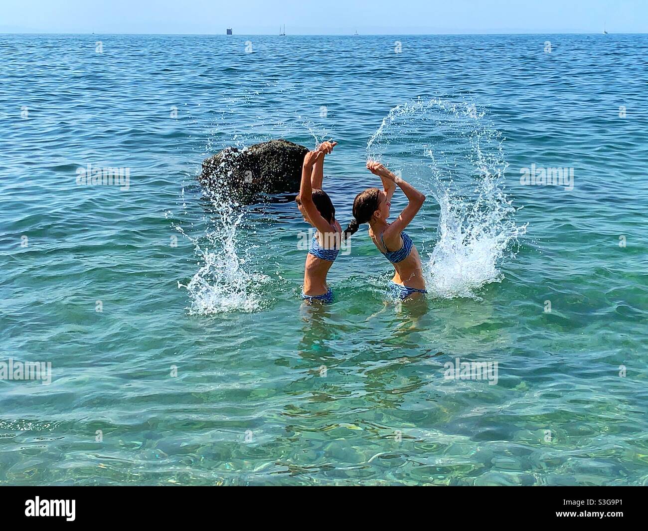 Jeunes filles jouant avec l'eau dans la mer. Banque D'Images