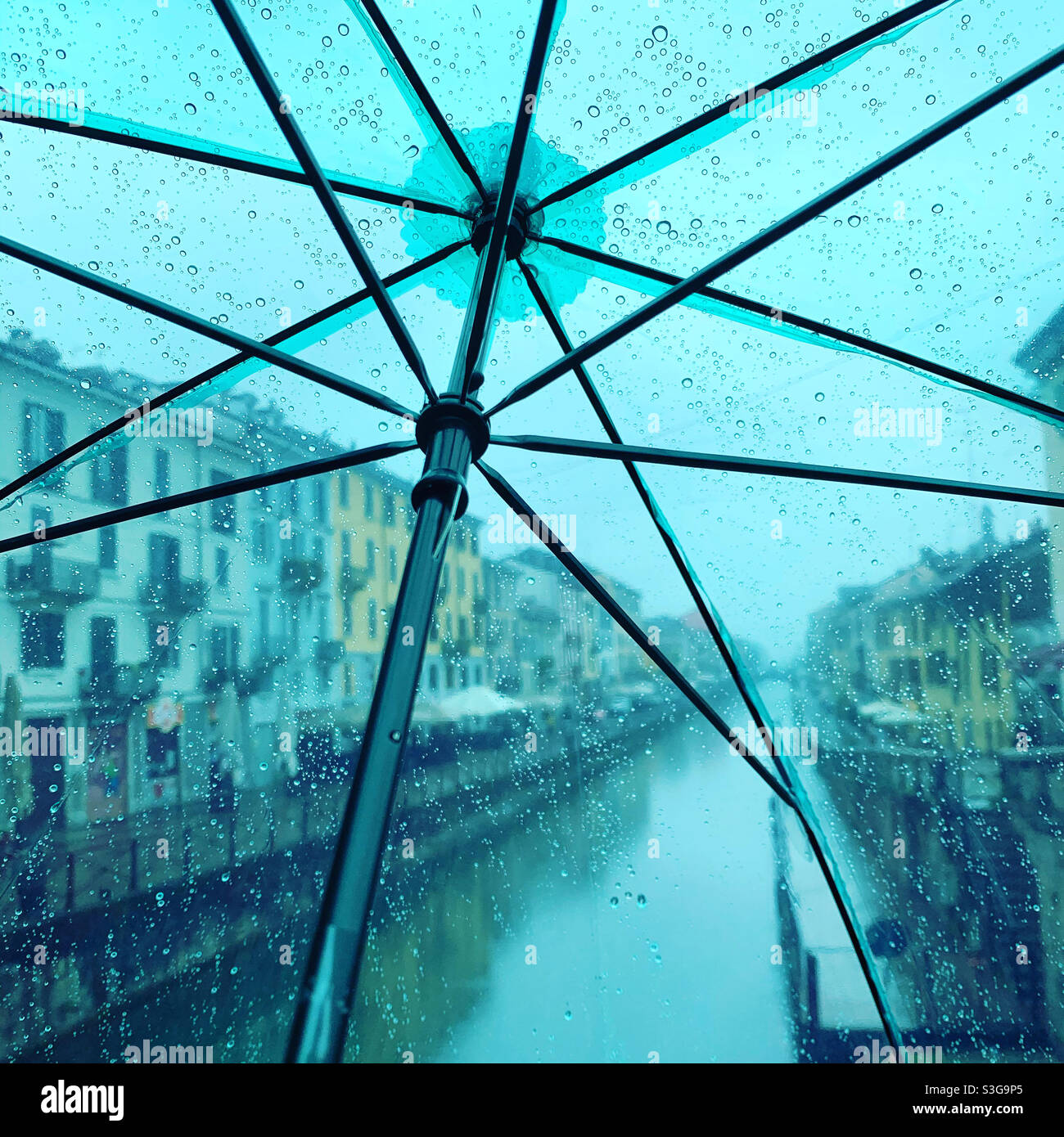 Naviglio Grande vu à travers un parapluie vert sous la pluie. Milan, Italie. Banque D'Images