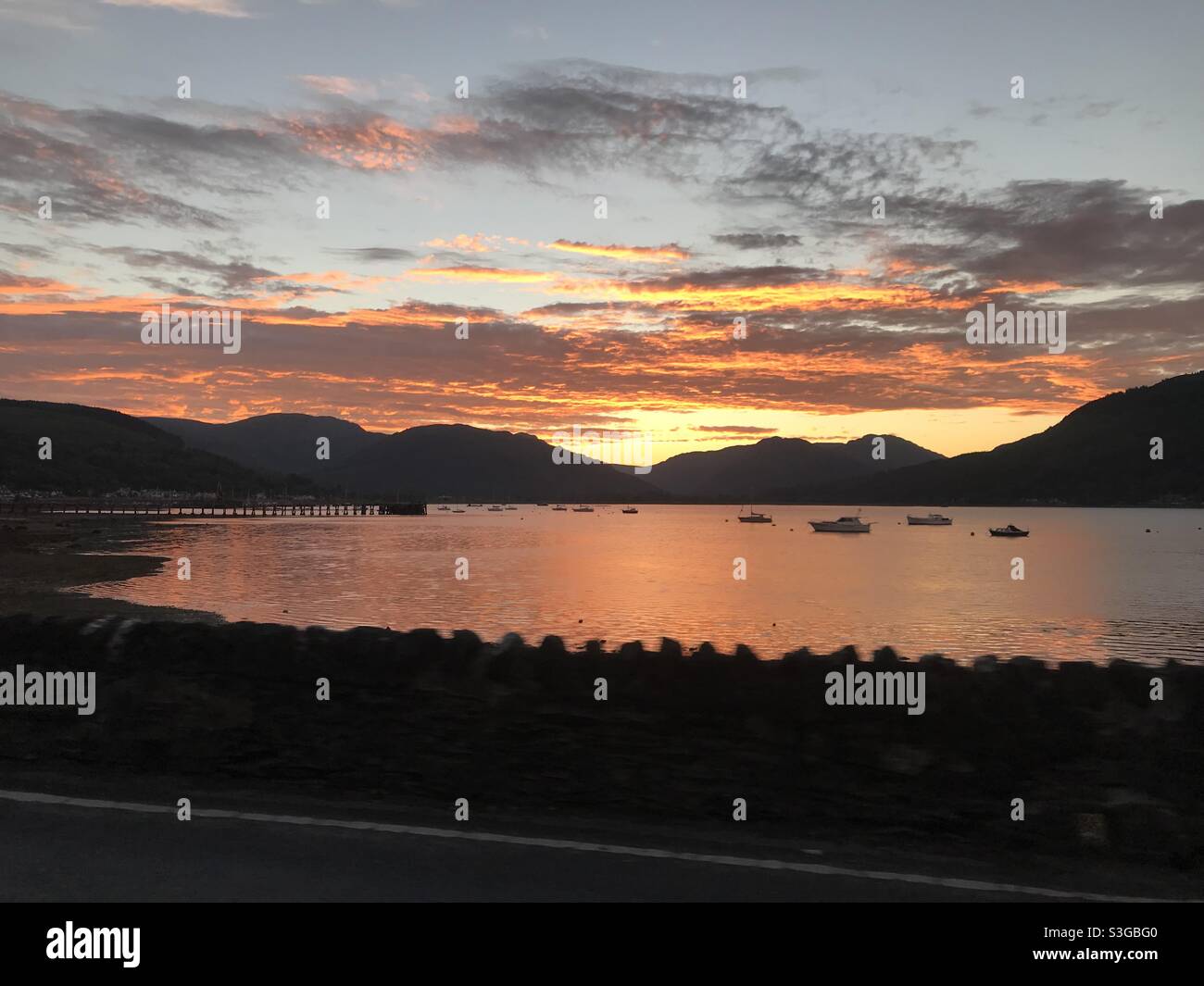 Vue sur la montagne et le lac avec coucher de soleil dans le ciel rouge Banque D'Images