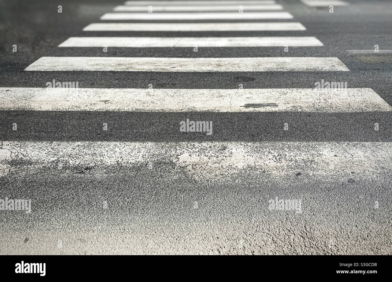 passage piéton d'une rue avec de l'asphalte usé et ruiné. Passage de Zebra dans une ville européenne. Panneaux de signalisation et passage piéton. Sécurité routière - Image de stock capturée avec un smartphone