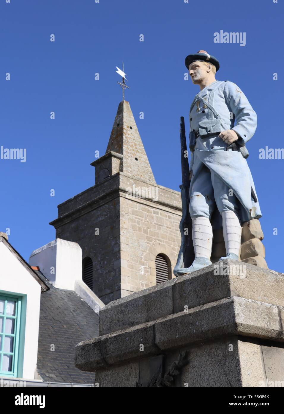 L'église de l'île Houat et la statue du rifleman marin à la mémoire des insulaires qui sont morts pour la France pendant les deux guerres mondiales , en Bretagne, Morbihan - Image de stock capturée avec un smartphone