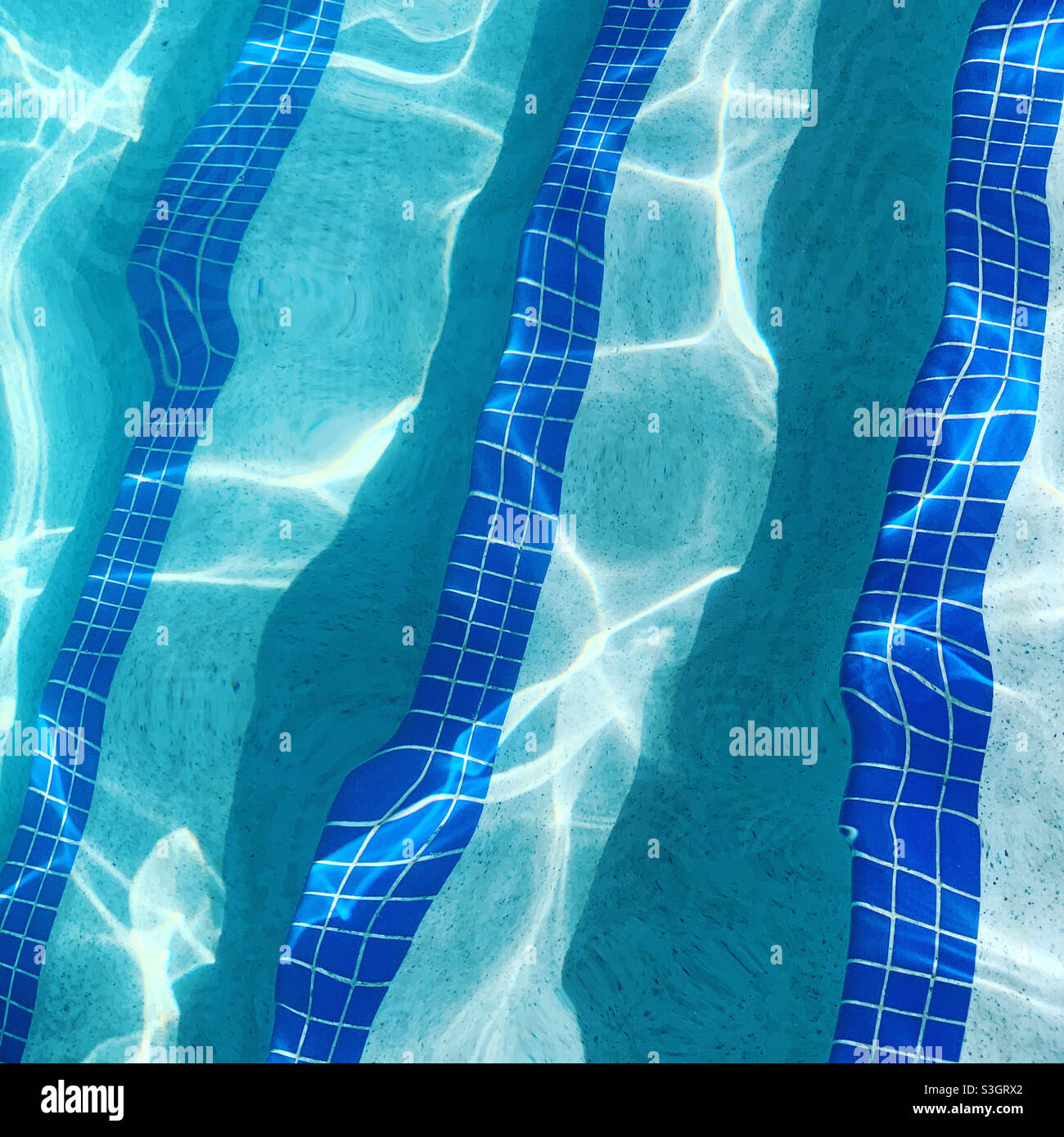 Lumière du soleil se reflétant sur l'eau d'une piscine de station avec des marches carrelées - Image de stock capturée avec un smartphone