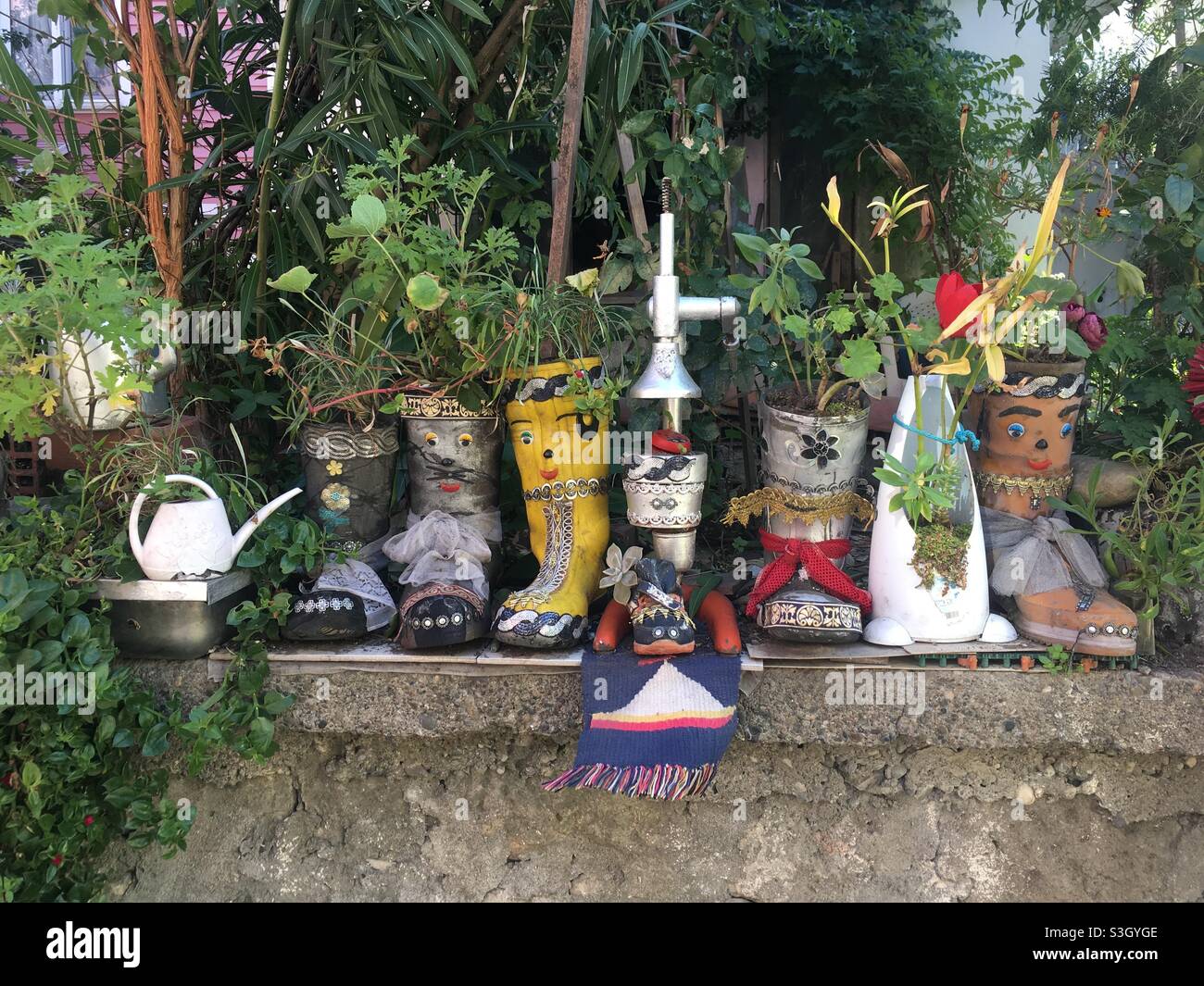 Amasra Türkiye’dé bir evin arka bahçesinde eski ayakkabı ve çizmelere ekilmiş bitkiler, plantes plantées dans de vieilles chaussures et bottes dans l'arrière-cour d'une maison à Amasra, Turquie Banque D'Images