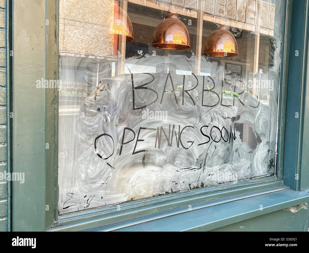 Panneau manuscrit dans les fenêtres d'un salon de coiffure - Image de stock capturée avec un smartphone