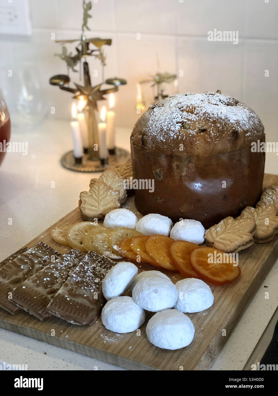 Buffet de friandises avec biscuits et panettone et carillons ange avec bougies Banque D'Images