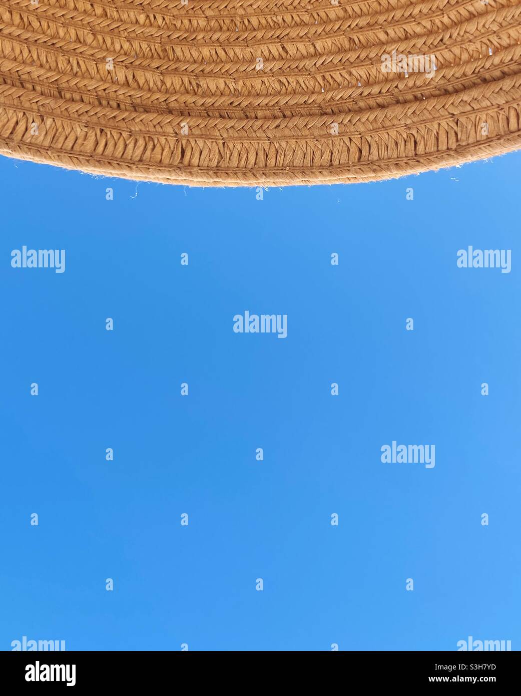 Vue sur le ciel bleu sous un chapeau de paille Banque D'Images