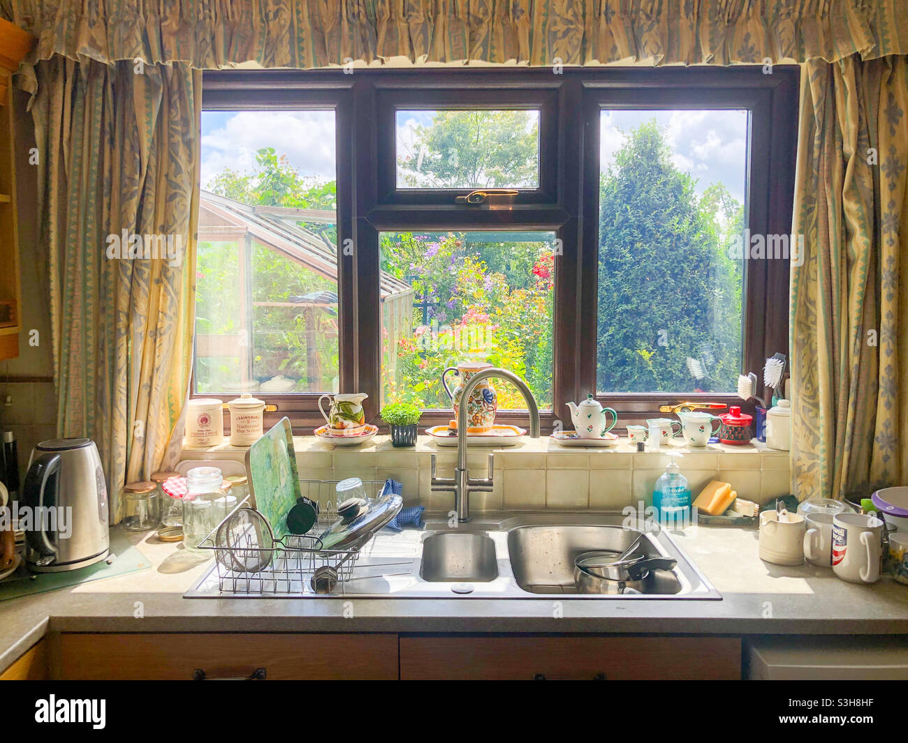 Un évier de cuisine et une fenêtre dans une maison familiale. Banque D'Images