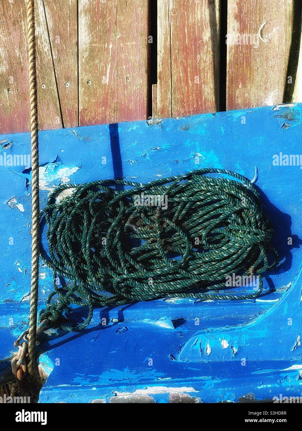 Corde située dans un petit bateau de pêche amarré dans un port de Cornouailles, août. Banque D'Images