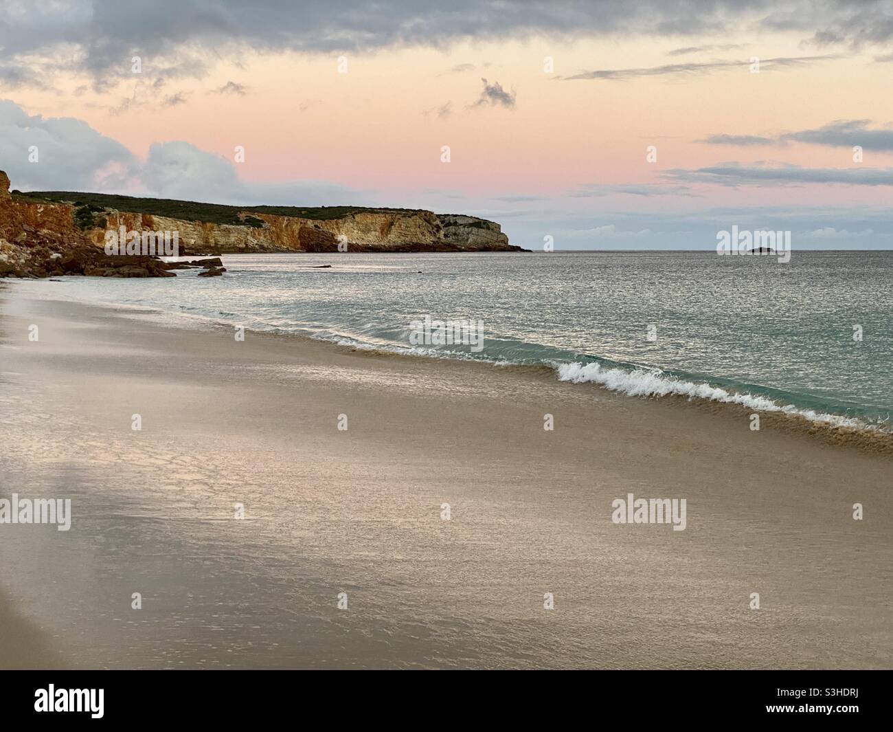 Plage vide en hiver avec mer calme et ciel rose Banque D'Images