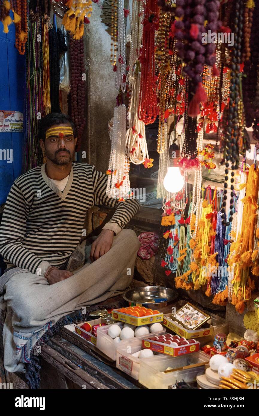 Un commerçant vendant des choses religieuses à Varanasi, en Inde Banque D'Images