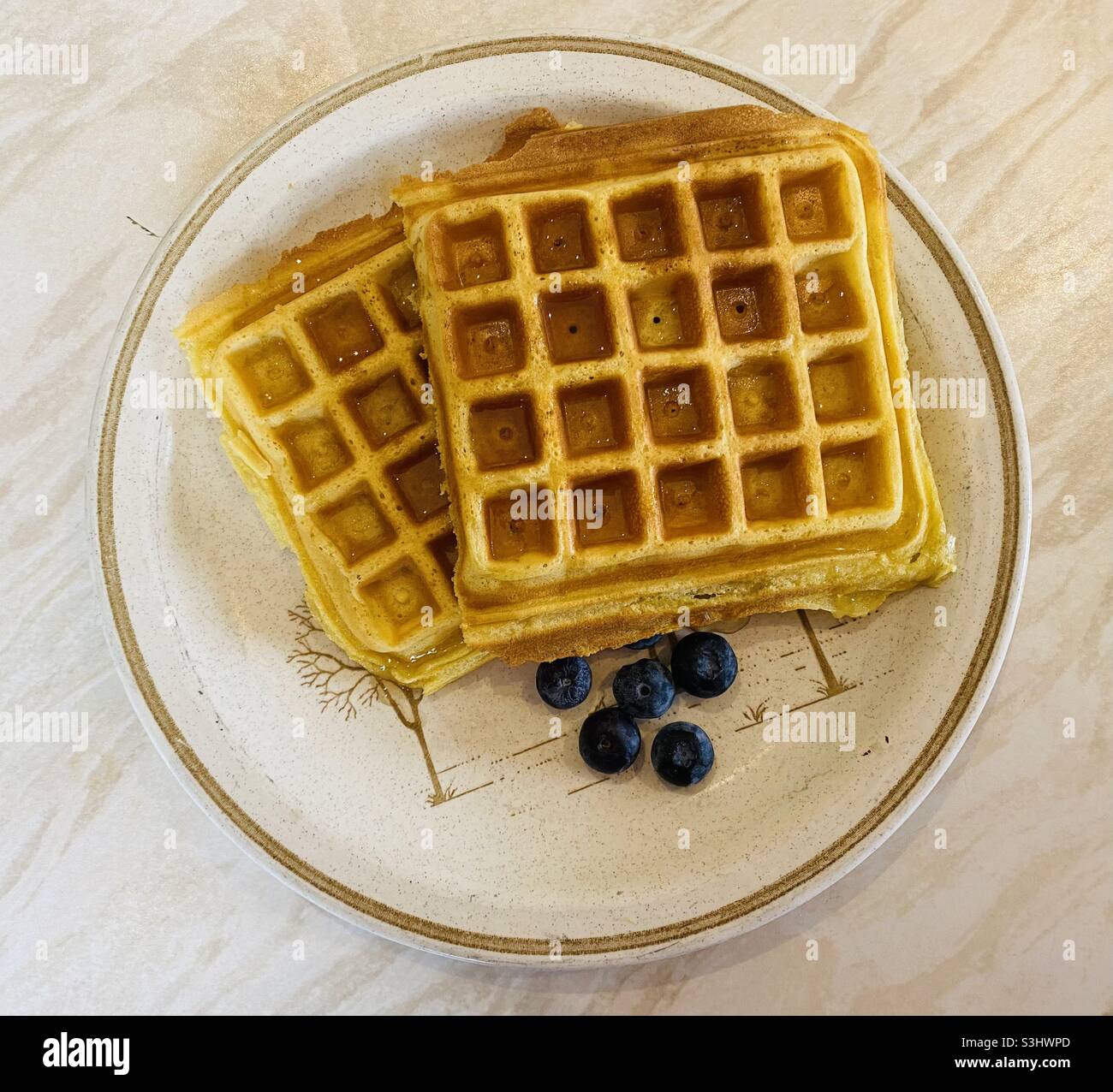 Gaufres avec miel et myrtilles sur une assiette. Août 2021. - Image de stock capturée avec un smartphone