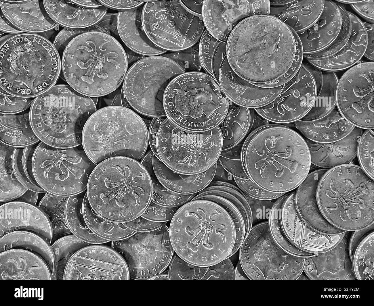 Un tas de pièces de 2 pence britanniques. Une vue familière dans les salles de jeux où les machines à sous sont jouées. La pièce 2p présente un portrait de la reine Elizabeth II et une plume de plumes. Photo ©️ COLIN HOSKINS. - Image de stock capturée avec un smartphone