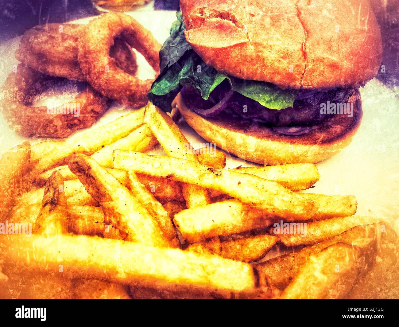 Hamburger servi dans un pain brioche avec des chips et des rondelles d'oignon, filtre de gringe appliqué Banque D'Images