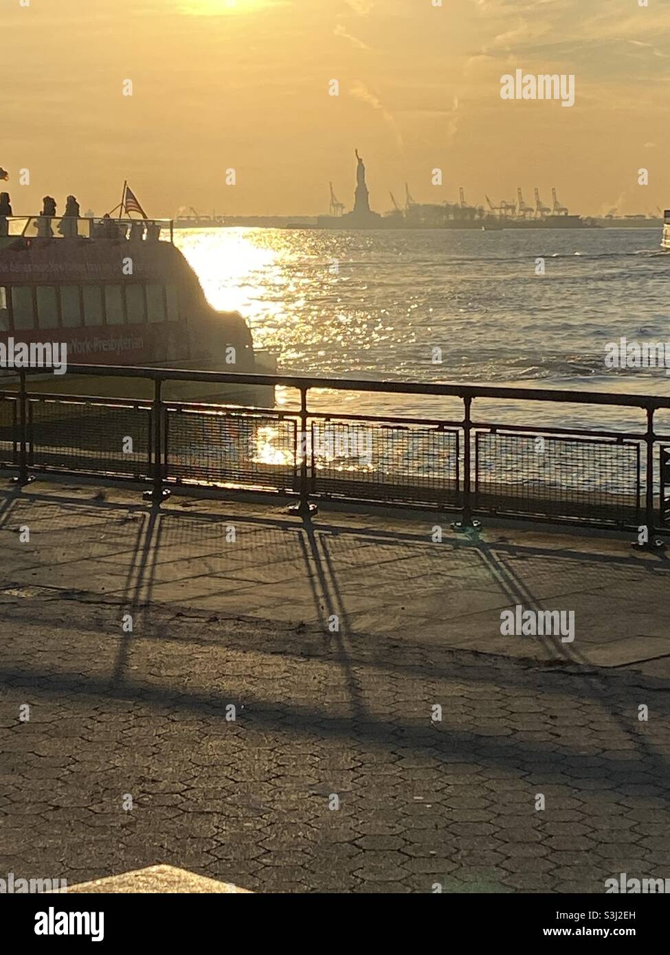 Coucher de soleil à New York sur la Statue de la liberté qui se reflète sur l'eau. Pris en décembre 2019 Banque D'Images