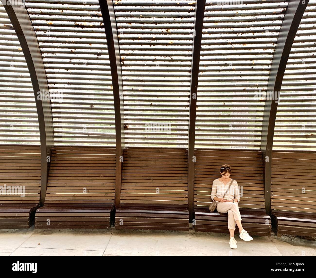 Femme assise sur le banc à l'extérieur Banque D'Images