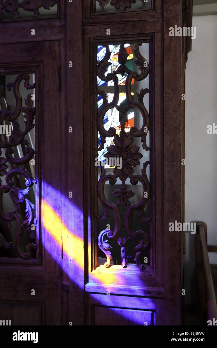 Lumière devant une porte en bois et vitraux dans l'église de l'île de Hoedic en Bretagne - Image de stock capturée avec un smartphone