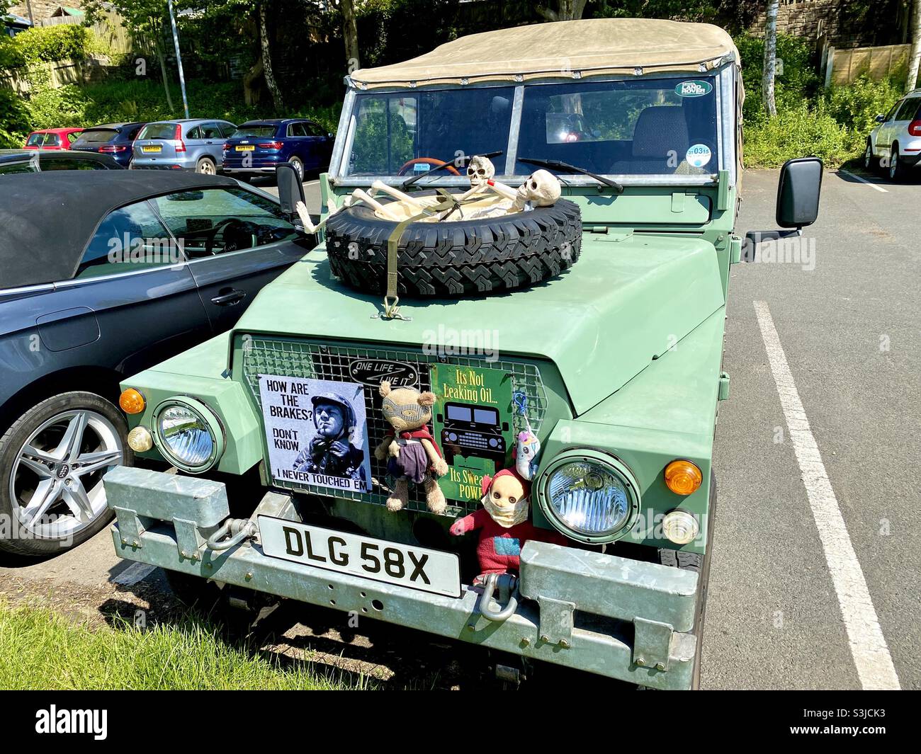 Vieille voiture décorée de poupées, de squelettes et de slogans amusants. Banque D'Images