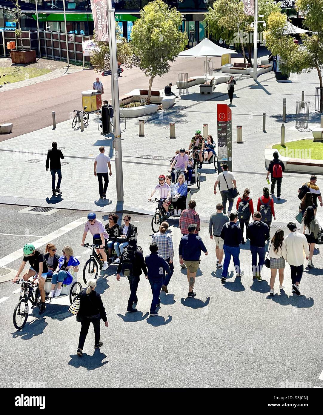 Touristes en tournée sur tricycles et piétons traversant la rue Wellington à Yagan Square Perth Australie occidentale Banque D'Images