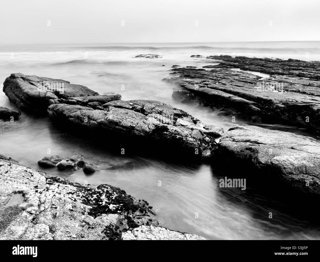 Les bassins de marée à exposition longue sont en noir et blanc Banque D'Images