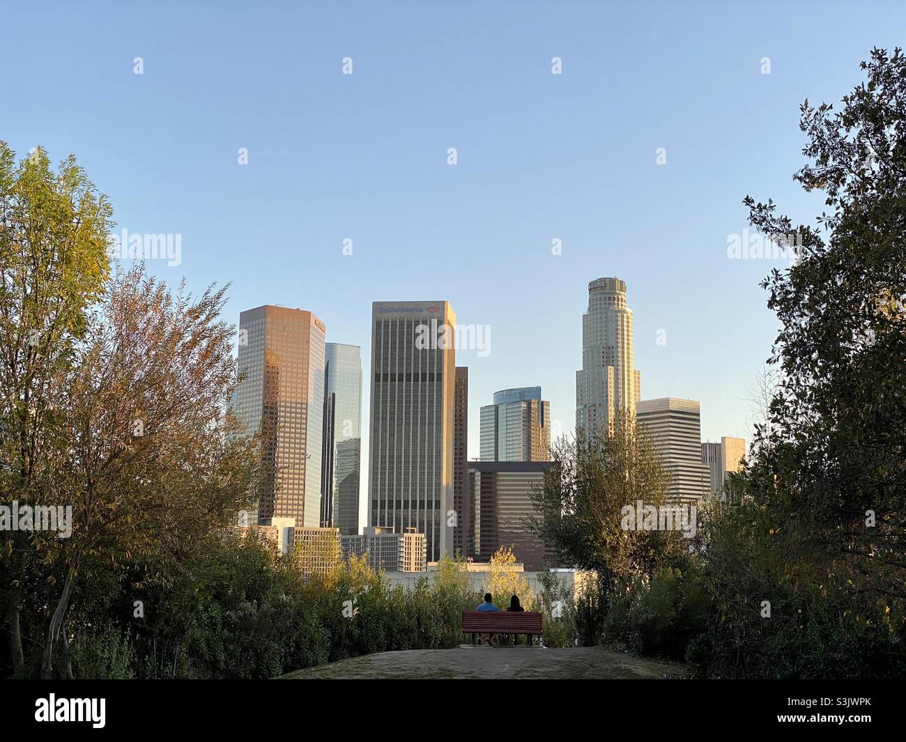 LOS ANGELES, CA, 2021 JANVIER : vue du centre-ville avec gratte-ciel vu du parc au nord de la ville, les gens ont silhoueté sur le banc en premier plan - Image de stock capturée avec un smartphone