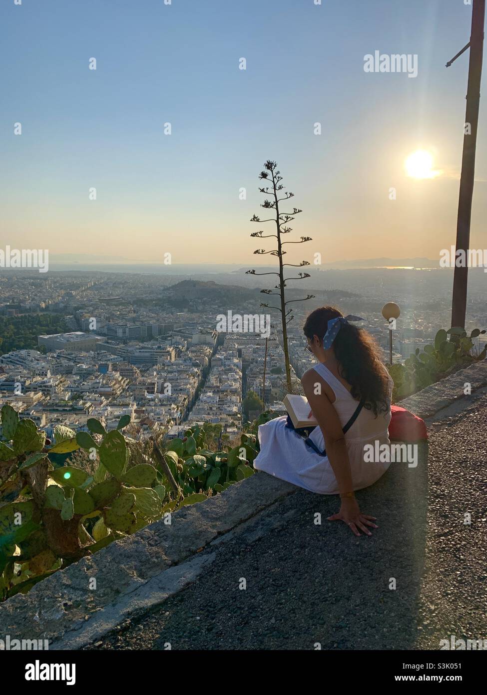 Une femme de la région lit le livre sur la colline de lycabette Athènes - Image de stock capturée avec un smartphone