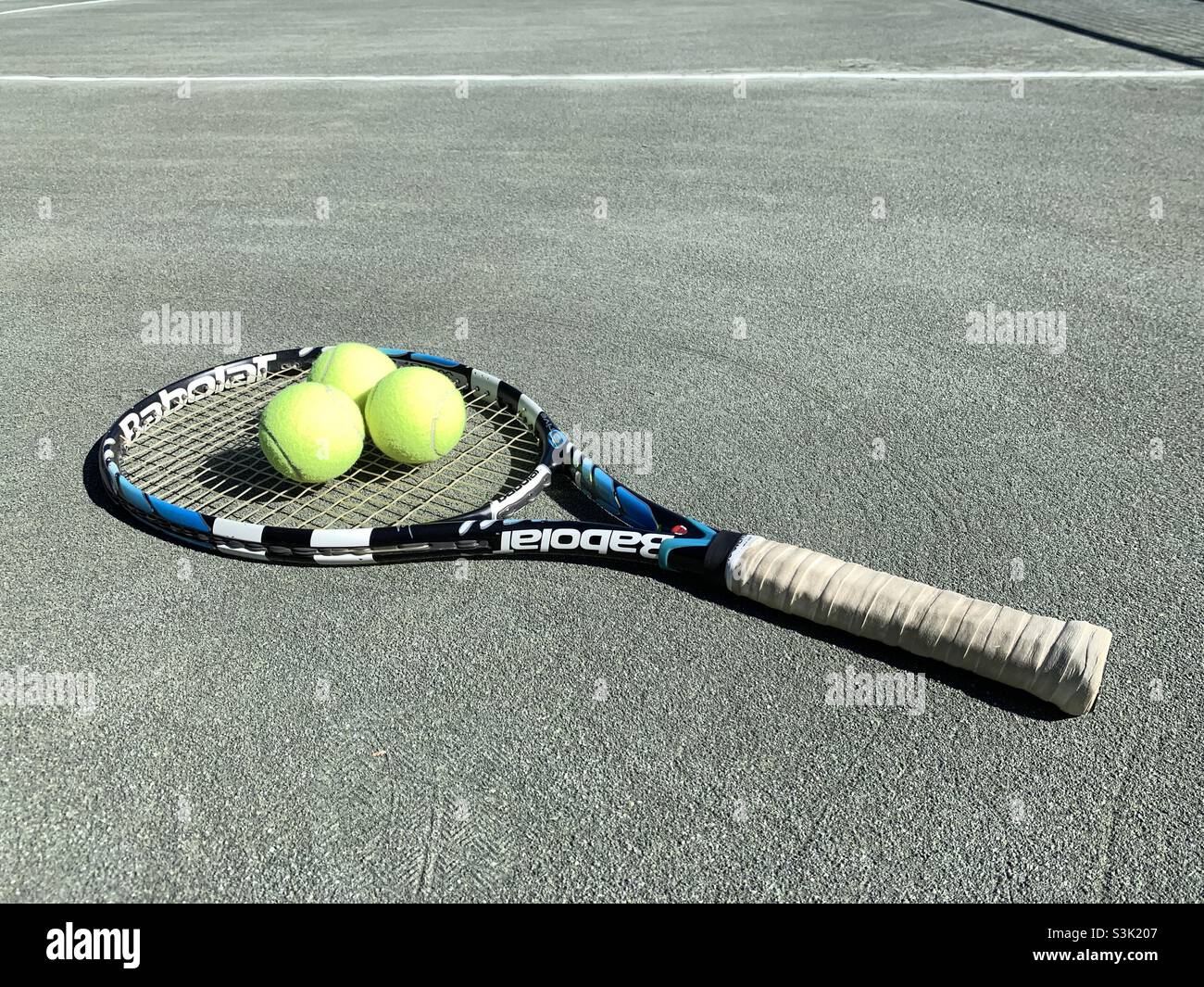 Balles de tennis coulées sur une raquette de tennis babolat blanc et bleu  Photo Stock - Alamy