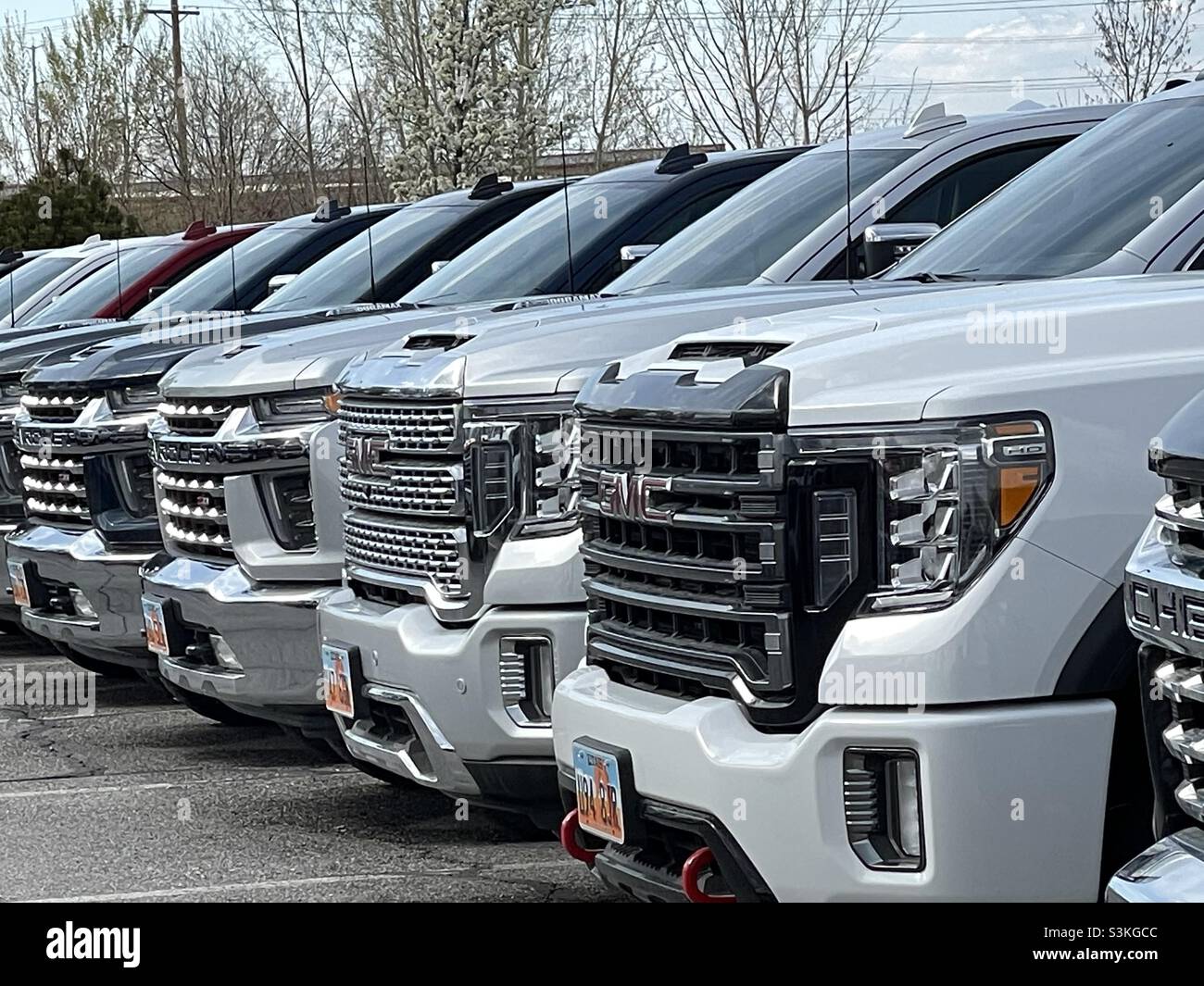 Les camions GMC neufs sont prêts à être vendus chez un concessionnaire. - Image de stock capturée avec un smartphone
