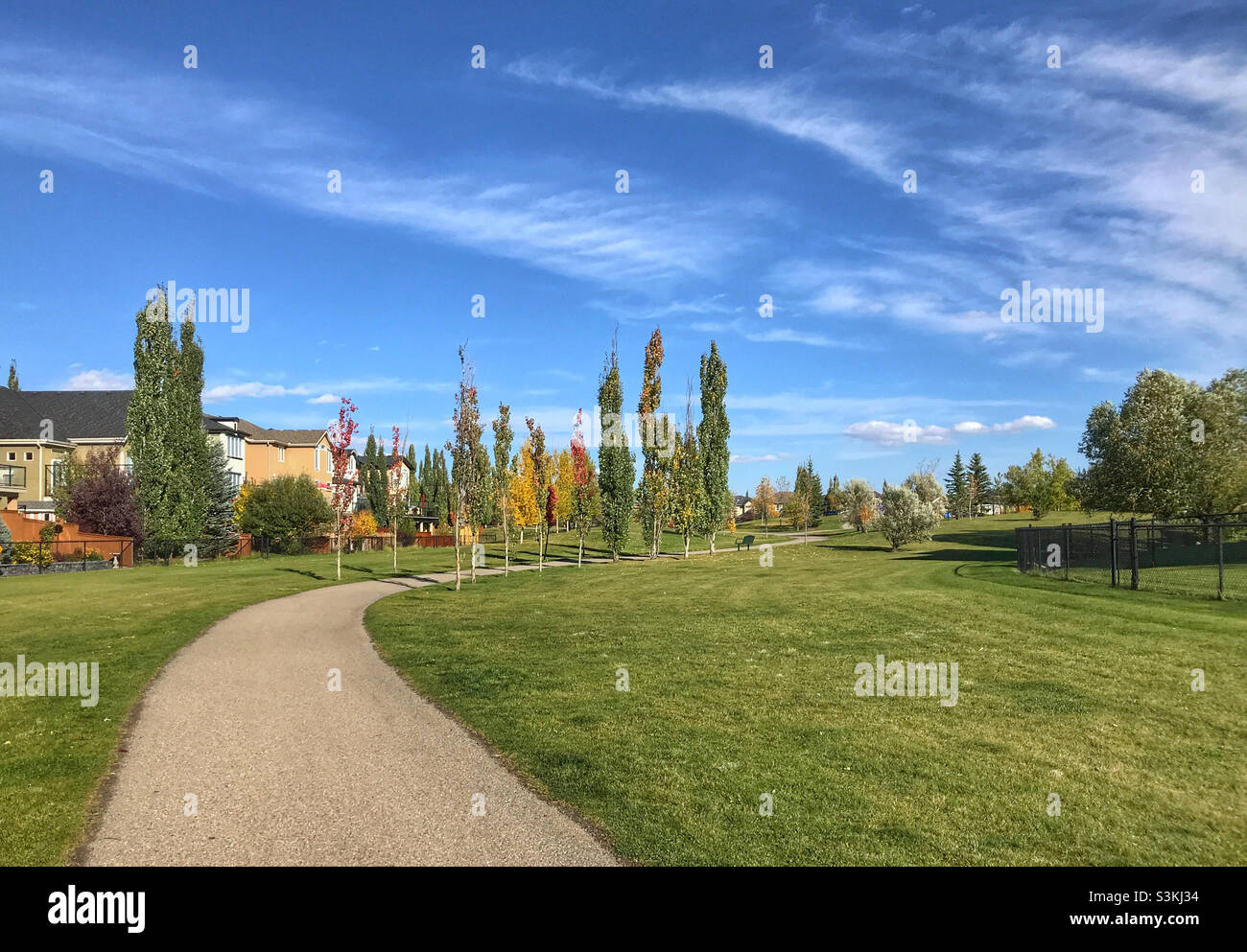Un sentier se démène dans un parc communautaire lors d'une journée d'automne à ciel bleu à Calgary, en Alberta, au Canada. Banque D'Images