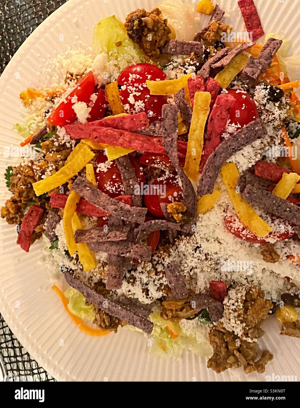 Gros plan d'une salade de tacos garnie de lamelles de tortilla et de fromage émietté - Image de stock capturée avec un smartphone