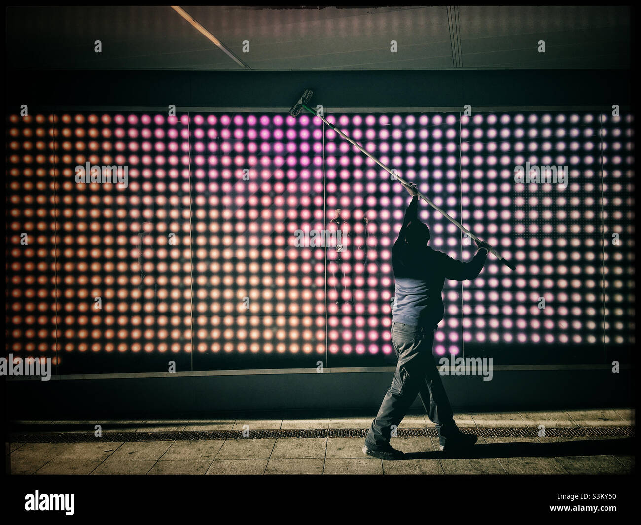 Homme nettoyant les lumières près du stade de Wembley - Image de stock capturée avec un smartphone