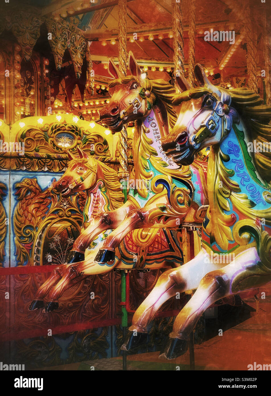 Trois chevaux sur un joyeux vont faire le tour du carrousel.Des moments de détente au parc des expositions.Souvenirs d'enfance.Effet grunge créatif.Photo ©️ COLIN HOSKINS. Banque D'Images