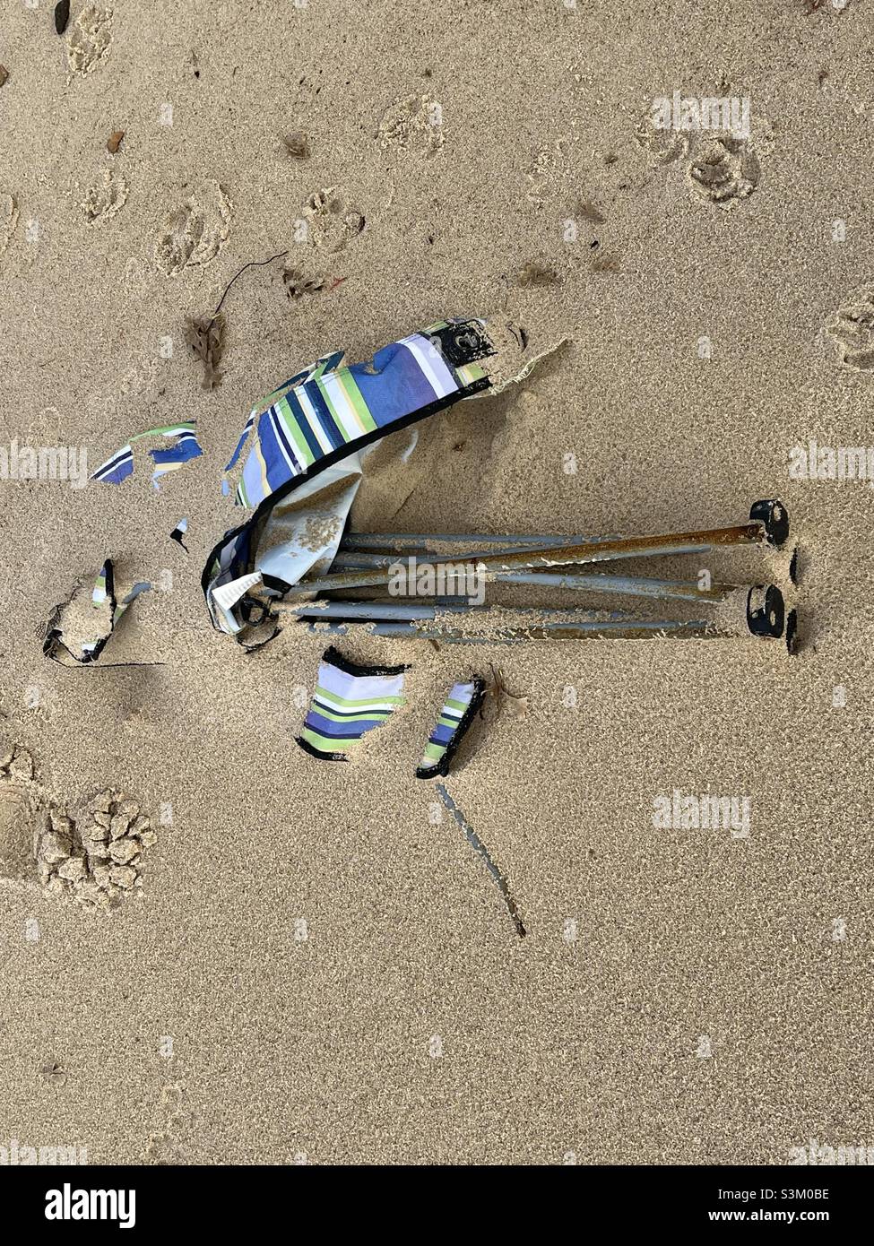 Chaise pliée en toile cassée laissée sur une plage de sable à Norfolk Banque D'Images