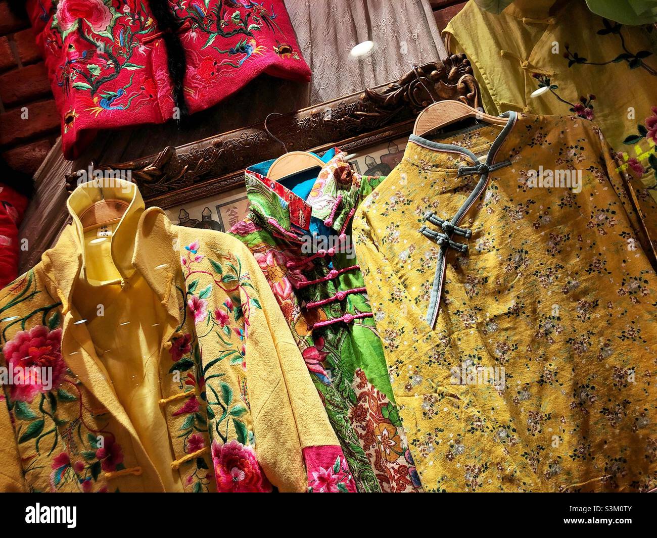 Des vêtements chinois traditionnels sont exposés dans une fenêtre de la boutique, Hong Kong Banque D'Images
