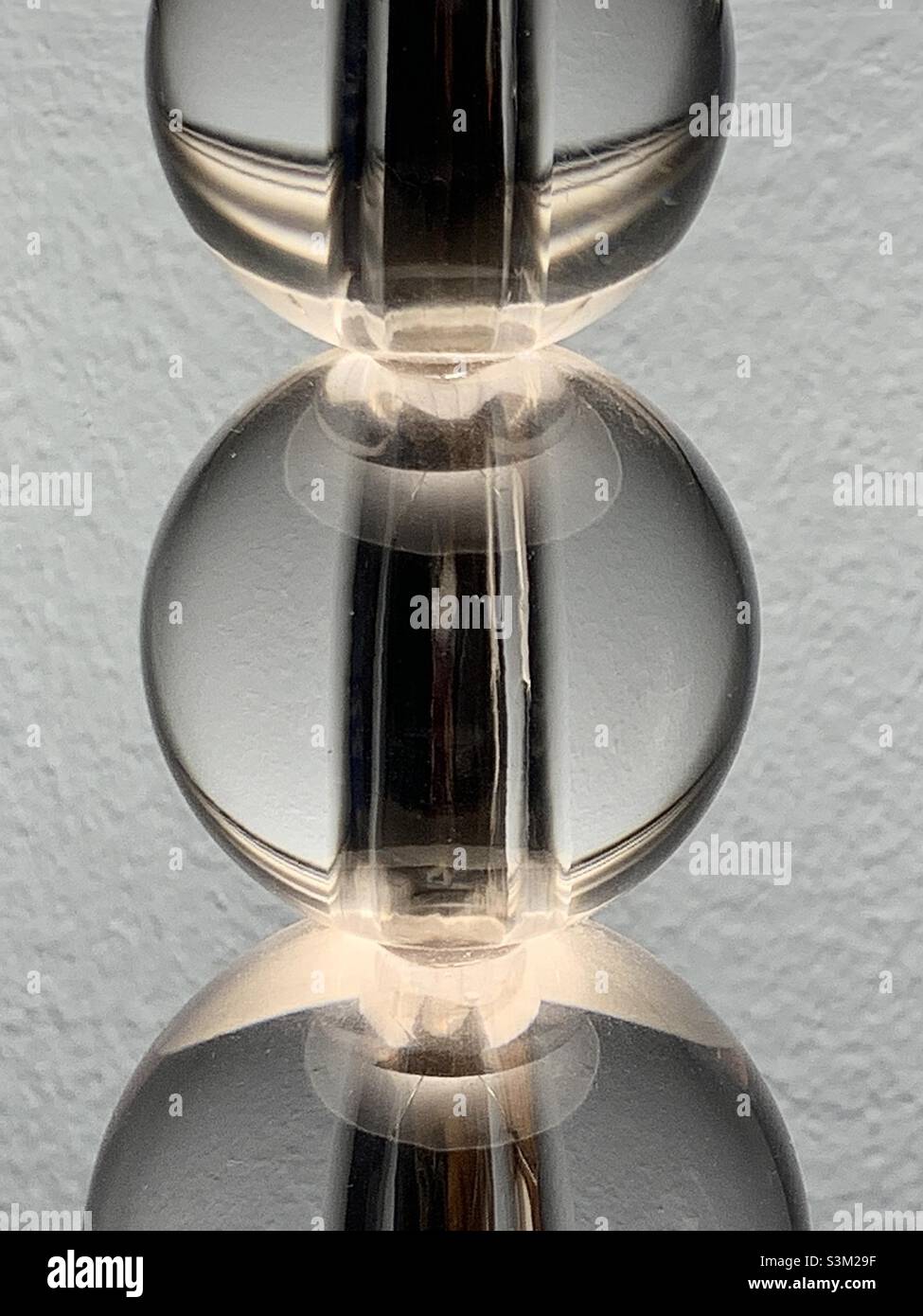 Corps d'une lampe composée de billes de verre transparentes, de taille variable, recouvrant une tige en acier.Avec la lampe sur elle fait une forme abstraite linéaire intéressante. - Image de stock capturée avec un smartphone
