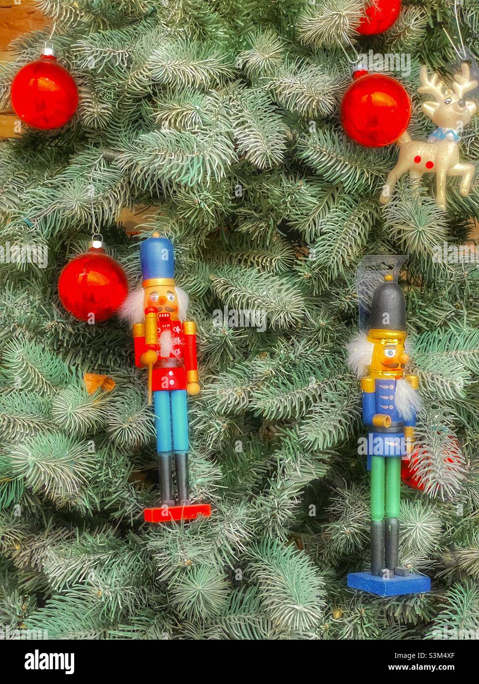 Un petit patio d'appartement, dans l'Utah, aux États-Unis, pendant la saison des fêtes, a un arbre de Noël décoré avec des ornements rouges et des casse-noisettes. - Image de stock capturée avec un smartphone